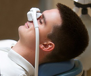 Patient relaxing while breathing in nitrous oxide in treatment chair