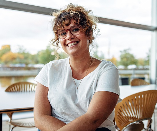 a young adult sitting at a table and smiling