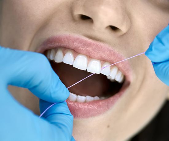 Dentist looking at patient’s smile in treatment room