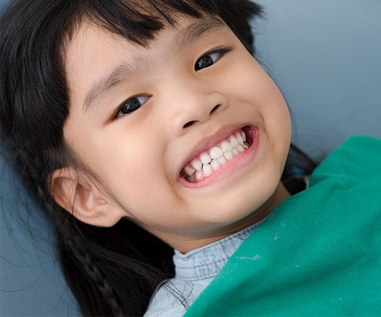 Child in dental chair smiling