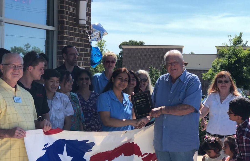 Dentist and team receiving award plaque