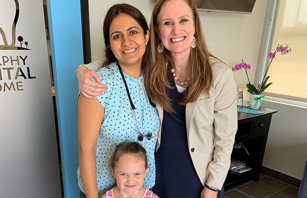 Dentist and mother and child smiling together