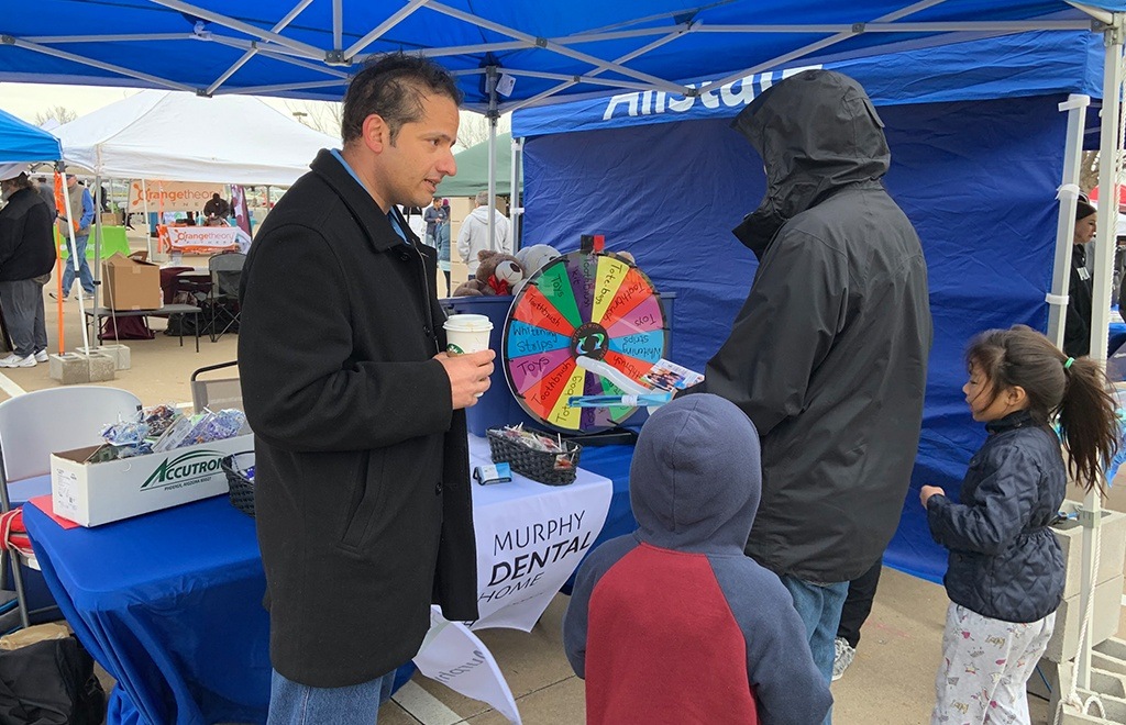 Dentist talking to family at community event