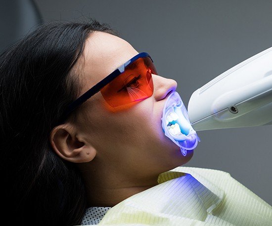 Woman receiving teeth whitening treatment