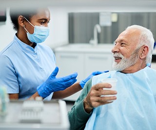 a denture candidate speaking with his dentist about treatment