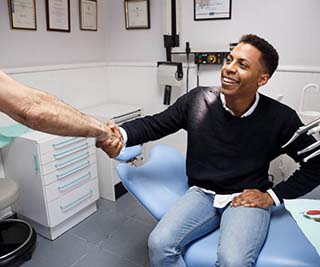 Patient shaking hands with dentist in emergency dental office in Murphy