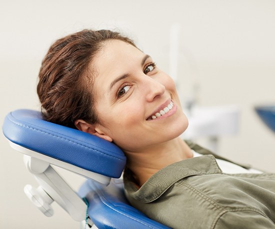 Woman smiling in the dental chair after tooth extraction in Murphy