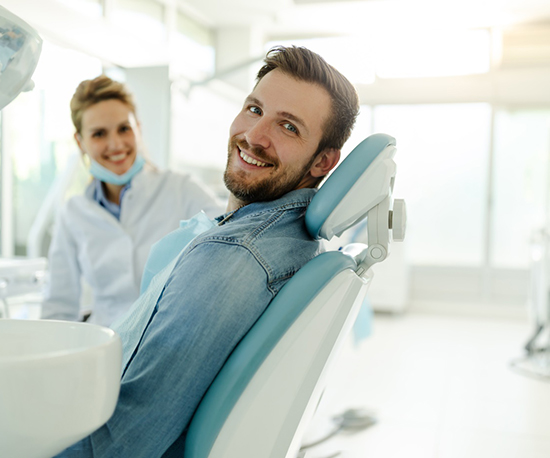 Happy dental patient looking over his shoulder