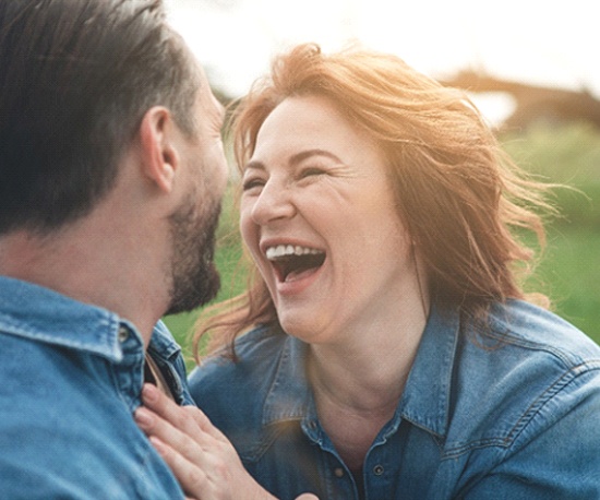 Couple smiling together outside wearing denim shirts