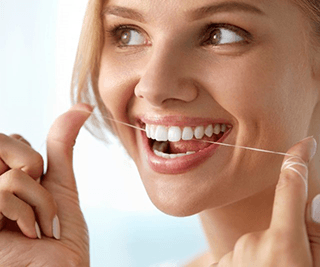 a woman in Murphy flossing her dental implants 