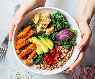 a person holding a bowl of healthy food
