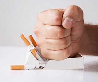 a person smashing a box of cigarettes