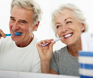 a mature couple brushing their teeth together