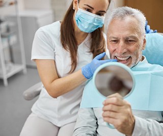 a patient checking his new smile with a mirror