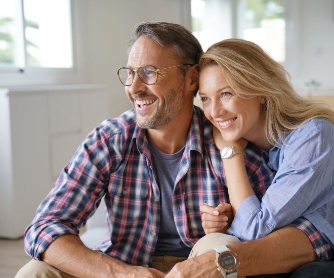 Smiling older man and woman sitting at home