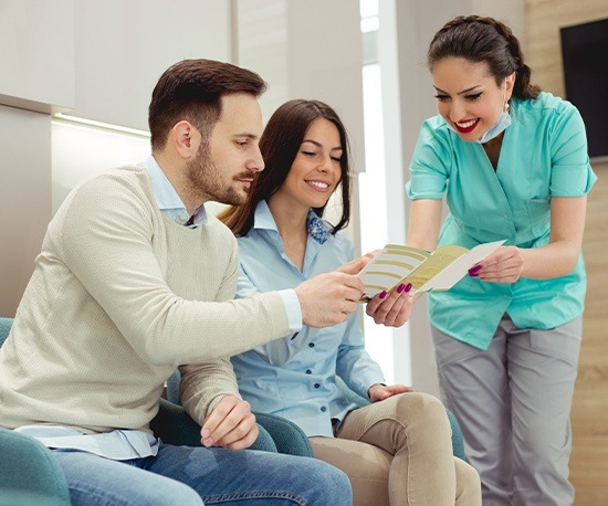 Man and woman talking to dental team member