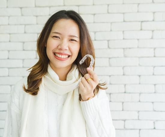 woman holding Invisalign in Murphy