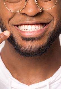 young man pointing to smile