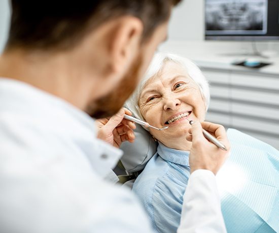 Woman in dental chair smiling at dentist