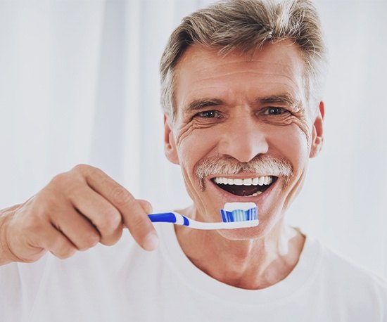 Older man brushing teeth