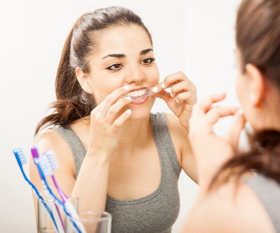 Woman placing teeth whitening strips
