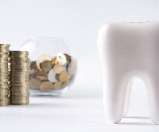 tooth next to a pile of coins