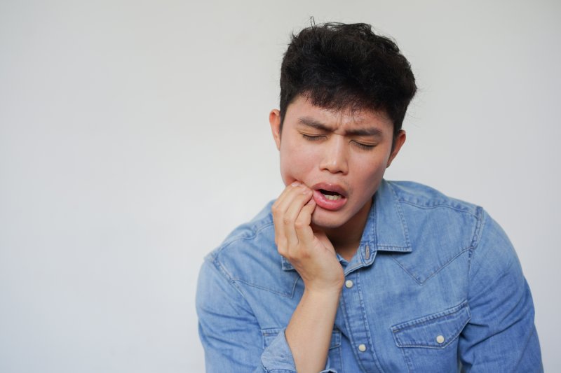 Man experiencing tooth pain from cavity 
