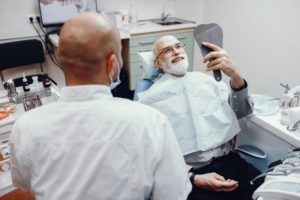 man admiring his new smile with dental implants in Murphy 