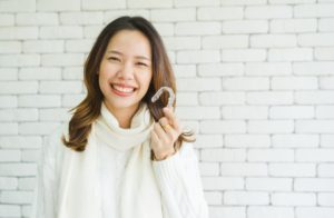 Woman showing the difference between Invisalign and veneers