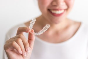 person holding a clear aligner for Invisalign in Murphy 