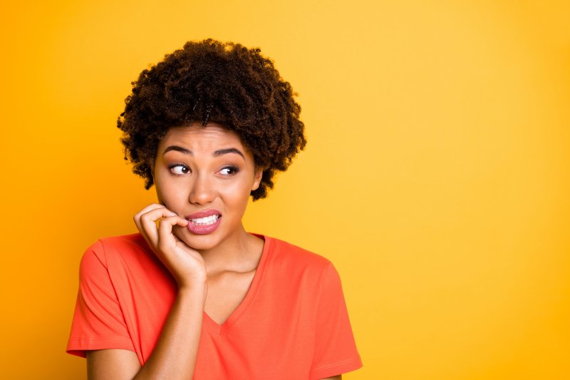 woman biting her nails with dental implants