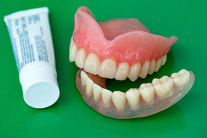 Denture next to a tube of adhesive