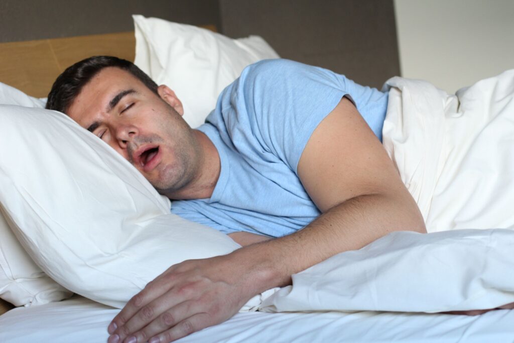 Man asleep in bed with mouth wide open