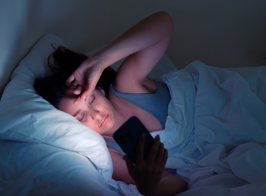 Woman laying in bed with phone