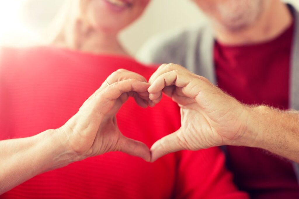 Two people making a heart shape with their hands.